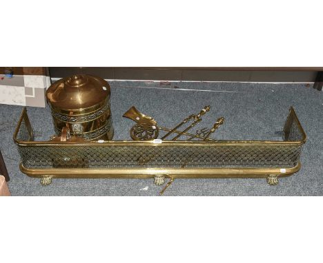 An Edwardian Brass Pierced Fender, with paw feet, a brass coal bucket with ring and lion mask handles, various fire tools; to