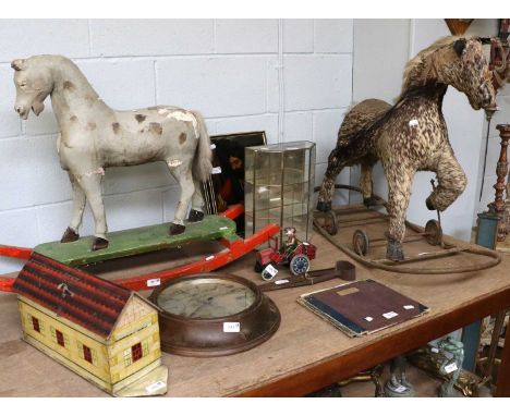 A Carved Pine Painted and Gesso Rocking Horse, a mid-20th century hide-mounted horse on a pull-along base (af), an early 20th