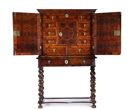A fine William &amp; Mary oyster veneered cabinet and stand, the swept pediment above two oyster veneered and roundel decorat