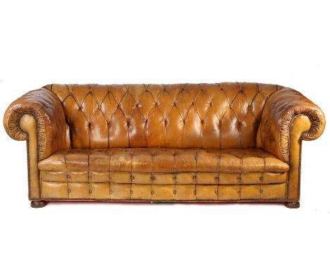 A Victorian leather upholstered chesterfield sofa, the button back and scroll arms above the button seat and front, raised on