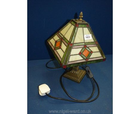 A Tiffany style electric table lamp with a square shape shade with geometric designs in green, white and red, a/f.