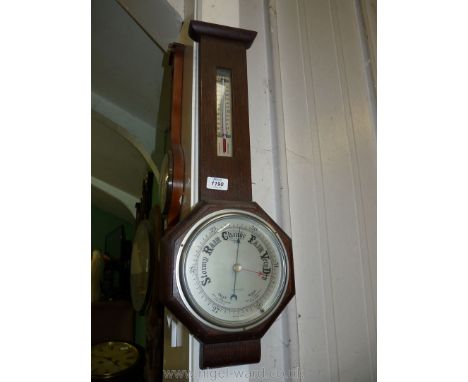 An Oak cased aneroid Barometer/Thermometer, the face with octagonal surround, 24 5/8'' high x 8 3/4'' wide