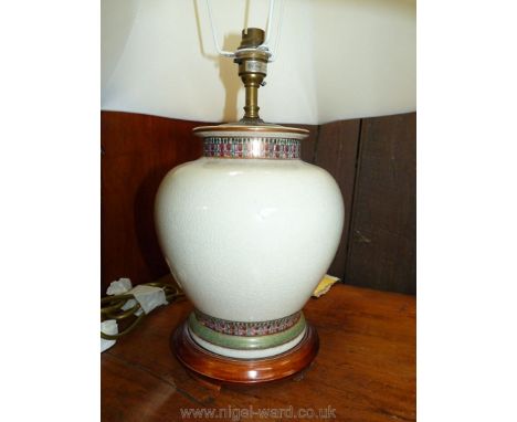 An elegant beige porcelain basedd table Lamp with gilt and polychrome friezes and of compressed baluster shape and complete w