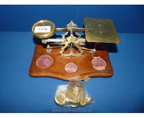 An old brass and wood Post Office scales with weights.