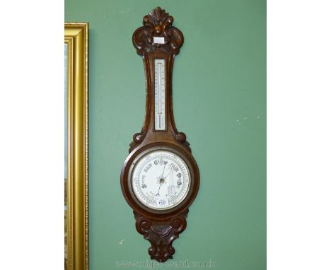 An elegant carved Oak cased Aneroid Barometer with thermometer, 34 1/2'' x 10 1/2'' wide