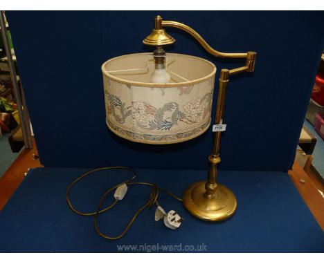 A brass cantilever lamp with cream shade.
