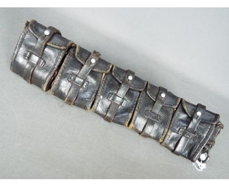 A vintage leather ammunition belt with five pouches.