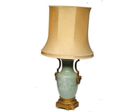 A 19TH CENTURY FRENCH PORCELAIN AND GILT METAL MOUNTED TABLE LAMP, the Celadon ground with foliate pate-sur-pate decoration, 