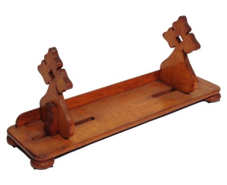 A VICTORIAN OAK BOOK SLIDE with pierced and shaped end supports, button feet, 66cm wide