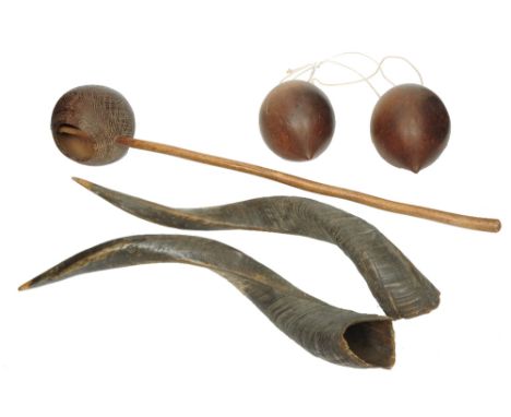 AN AFRICAN CARVED WOODEN LADLE with stick handle and incised decoration, 63cm long, a pair of polished coconut shells and a p