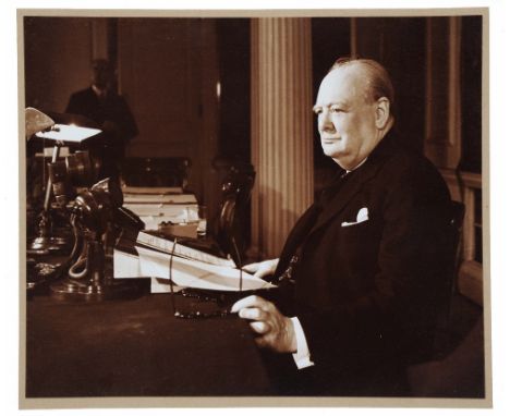 A PHOTOGRAPHIC PORTRAIT of Sir Winston Churchill seated at his desk, 24 x 30cm in hand-made frame by David Joel Ltd