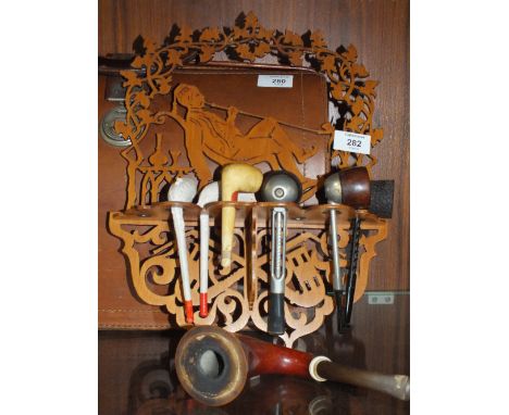 A VINTAGE CARVED WOODEN PIPE RACK A/F TOGETHER WITH PIPES