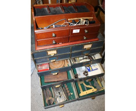 A WATCHMAKERS TEN DRAWER DESKTOP CHEST OF DRAWERS CONTAINING WATCHMAKERS TOOLS, CLOCK PARTS ETC. TOGETHER WITH A DESKTOP DISP