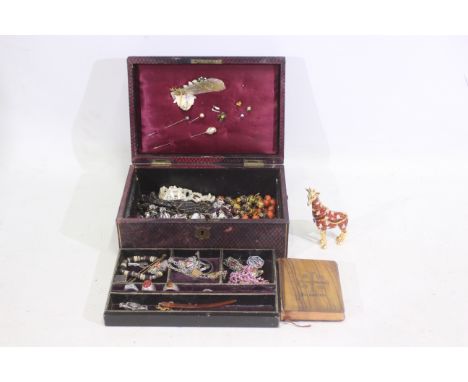 A jewellery box containing various costume jewellery and an orange enamel giraffe compact. The compact has green eyes and gil