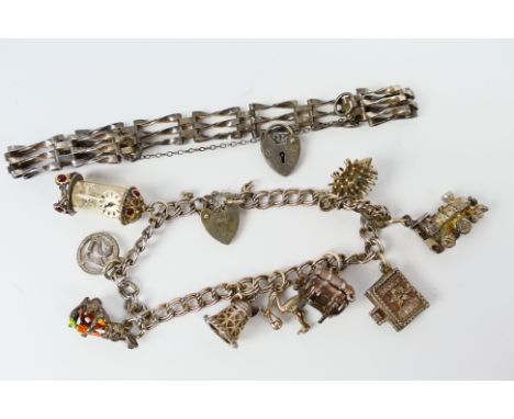 A white metal charm bracelet with padlock clasp stamped Silver and nine charms to include hedgehog , clock, train, bible and 