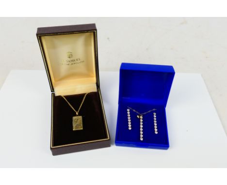 A yellow metal stone set suite comprising pendant on fine trace chain with a pair of matching earrings, chain, pendant and bu