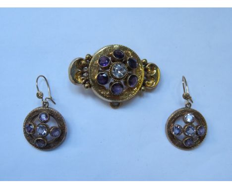 UNHALLMARKED VICTORIAN STYLE GOLD COLOURED BROOCH SET WITH CENTRAL CLEAR STONE AND SIX AMETHYST STONES.  ALSO MATCHING EARRIN