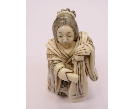 HEAVILY CARVED IVORY NETSUKE OF A MUSICAL FIGURINE, SIGNED TO BASE, APPROXIMATELY 5.5cm HIGH 