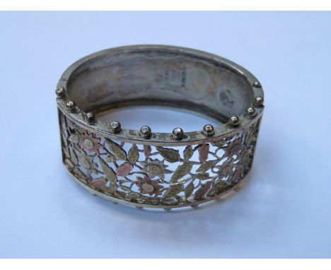 HALLMARKED SILVER AND TRI-GOLD COLOURED PIERCEWORK AND FLORAL DECORATED SNAP BANGLE 