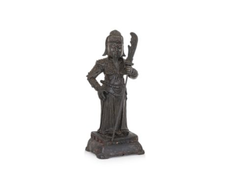 A BRONZE STANDING GUANDI Late Ming dynasty, modelled wearing armour and robe, holding his guandao polearm in right hand, on i