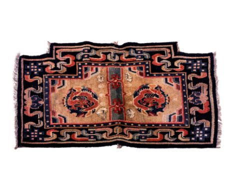 A DRAGON MEDALLION TIBETAN SADDLE RUG
1st half 20th century, hand-knotted wool in beige and blue tones, two central flying dr