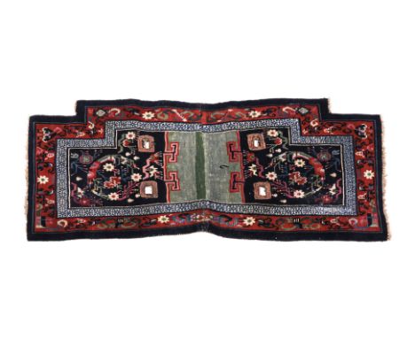 A BLUE AND MAROON TIBETAN SADDLE RUG
1st half 20th century, hand-knotted wool, two central blue ground panels of various flow