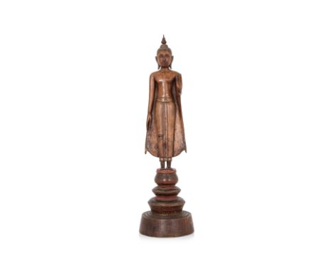 A THAI CARVED SANDALWOOD FIGURE OF STANDING BUDDHA
Ayutthaya style 18th/19th century, 
Modelled standing, the left hand raise