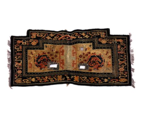 A DRAGON MEDALLION TIBETAN SADDLE RUG
1st half 20th century, hand-knotted wool in beige and black tones, central dragon medal