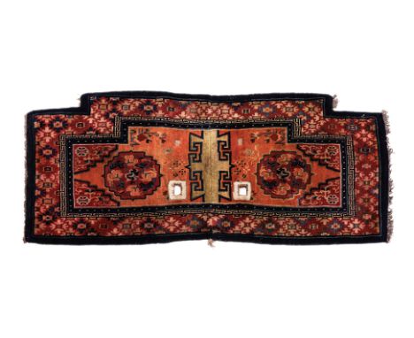AN ORANGE AND RED TIBETAN SADDLE RUG
1st half 20th century, hand-knotted wool, two central foliate medallions surrounded by p