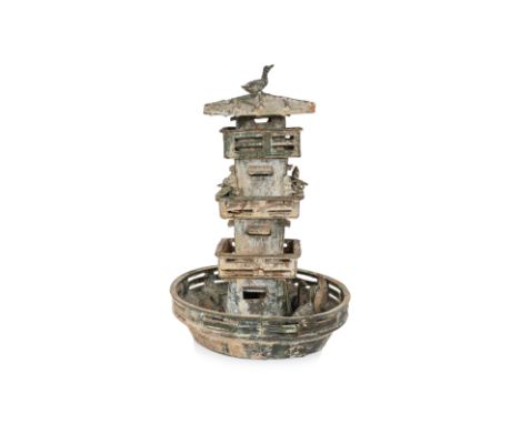 A GREEN-GLAZED POTTERY MODEL OF A WATCH TOWER
Han dynasty, rising from a circular basin containing fish and birds, three gall