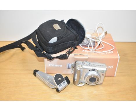 A Canon PowerShot A530 Digital Camera with hama stand and charging cable