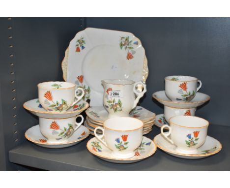 A vintage Pheomix china part tea service hand coloured in the art deco style with orange edging and foliage on a white ground