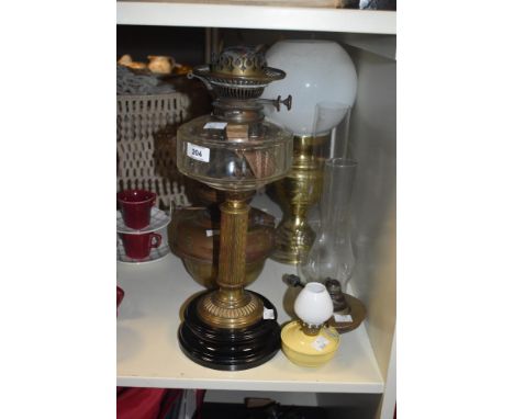 A vintage oil lamp having glass bowl and brass column complete with glass flute, measuring 66cm overall sold together with tw