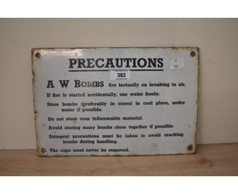 A 20th century enamel sign reading 'precations A W Bombs' having black text on a white ground, w30cm