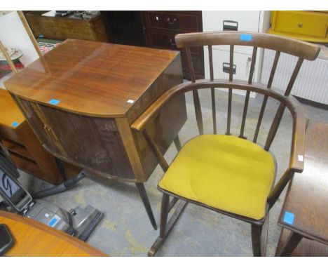 A mid 20th century stick back rocking chair, together with a tambour fronted cabinet 