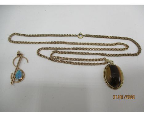 A 9ct gold pendant set with tigers eye on a yellow metal chain and a 9ct gold dollar pendant 