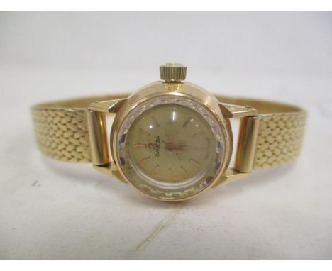 A 1960s Omega yellow metal ladies manual wind wristwatch having a gilt dial with baton markers and inscription to the case ba