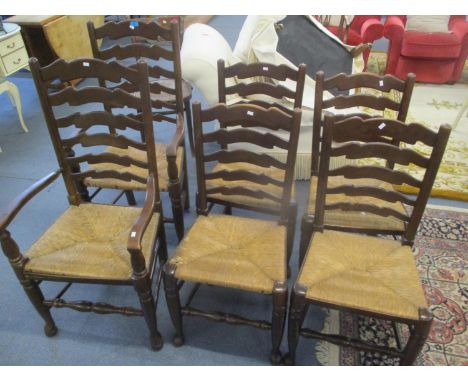 A set of six oak ladder back, rush seated dining chairs, two being carvers 