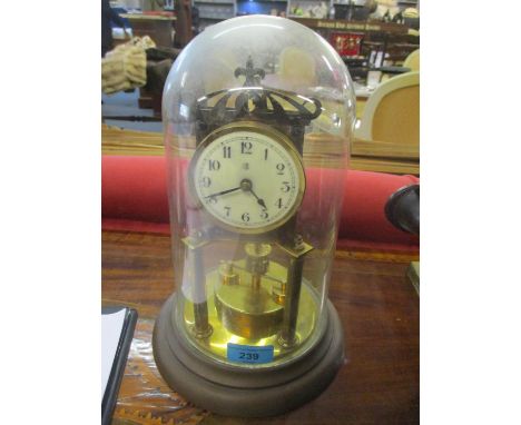 An early 20th century brass anniversary clock with a glass dome 