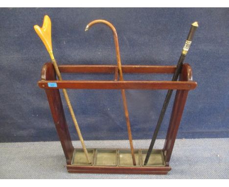 A mahogany umbrella/stick stand with four drip trays, a vintage sword stick and another of unknown purpose/origin, and a silv