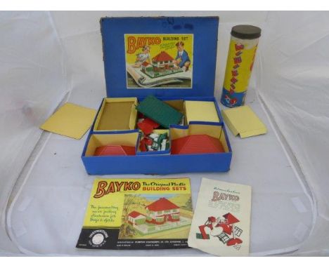 A boxed Bayko Building Set and a cylindrical cardboard Minibrix Premier Set.