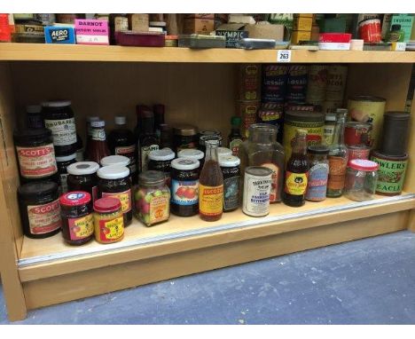 A shelf full of food packaging, many with reproduction labels. 