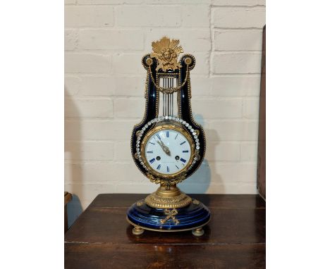 A Louis XVI style mantel clock in ormolu and porcelain lyre shaped case, with ornate mounts and pedestal base,white enamel ci