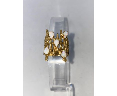 A 1960's/70's modernist yellow metal dress ring, pierced bark effect set 5 opal coloured stones, stamped '14k', 9.3 gm size '