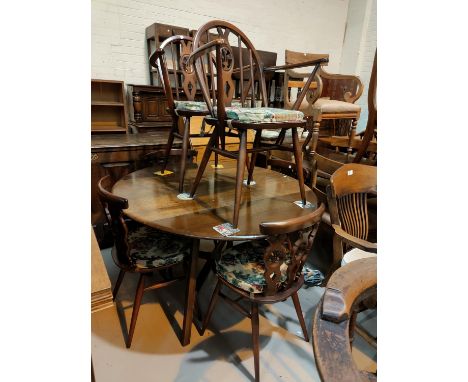 An Ercol dark oak dining suite comprising drop leaf circular table and 4 fleur de lys chairs, 2 similar hoop and stick back c