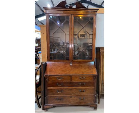 A George III mahogany bureau with fall front enclosing central boxwood inlaid cupboard door flanked by sliding compartments, 