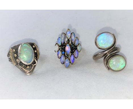 A 1960's/70's modernist yellow metal dress ring with elliptical opal coloured stone and small blue stones in tiered setting s