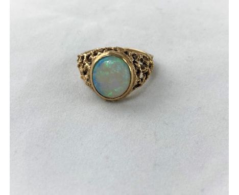 A 1960's/70's modernist 9 carat hallmarked gold dress ring with naturalistic pierced shoulders, set oval opal coloured stone,