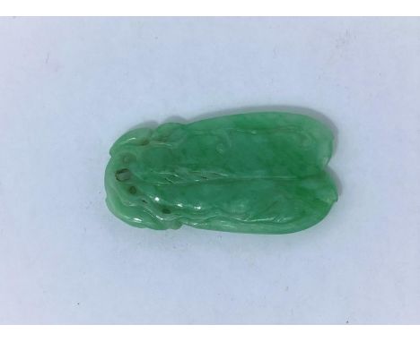 A Chinese light green jade coloured pendant in the form of two pieces of fruit. In good condition