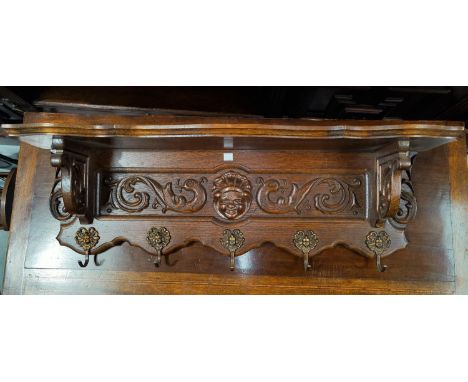 A carved oak reproduction wall shelf/coat rack in the French manner length 84cm 